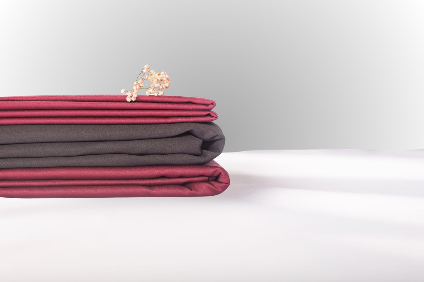 Texture detail of burgundy and black sateen bed linen by Once@Home with subtle sheen and soft touch