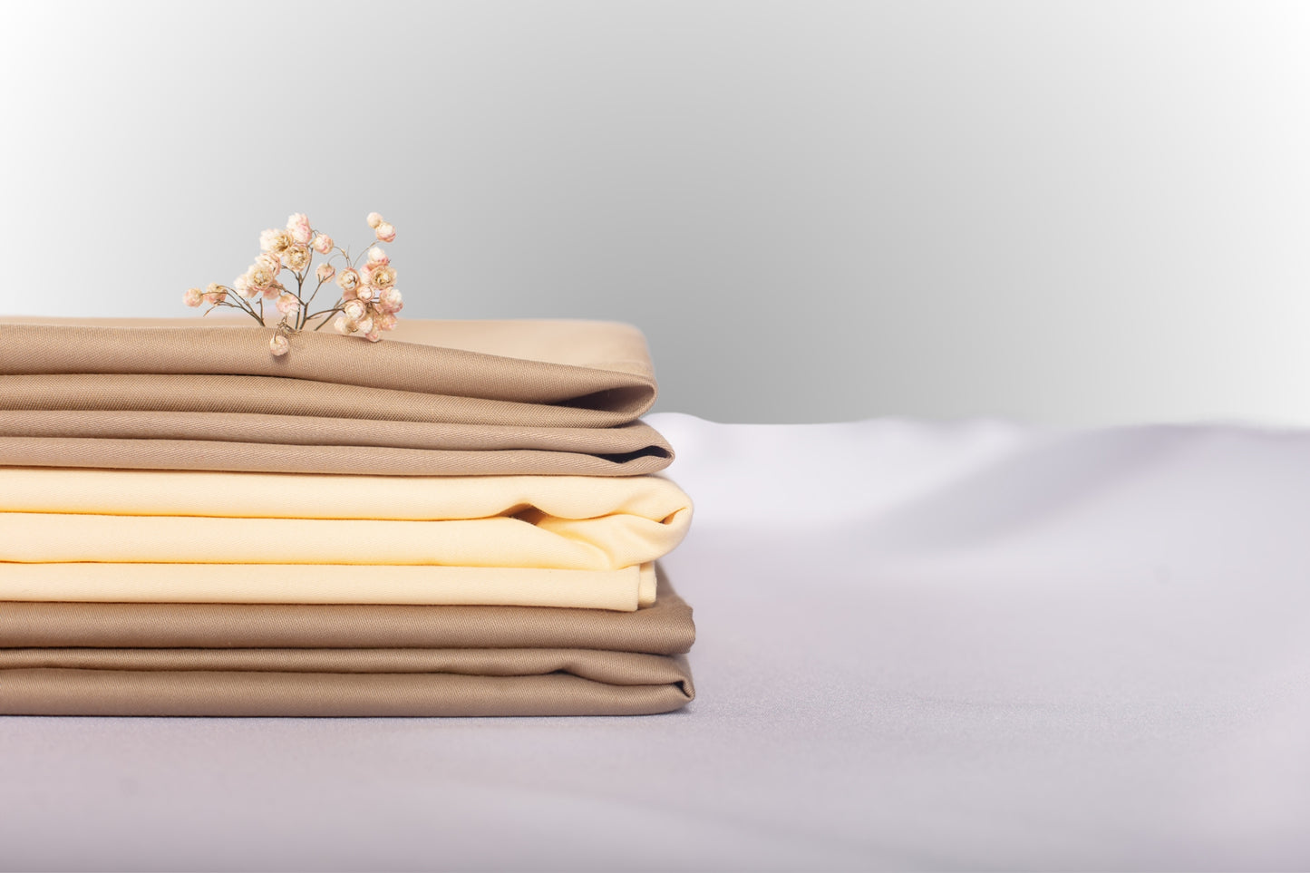 Texture detail of cream-beige sateen bed linen by Once@Home with subtle sheen and soft touch