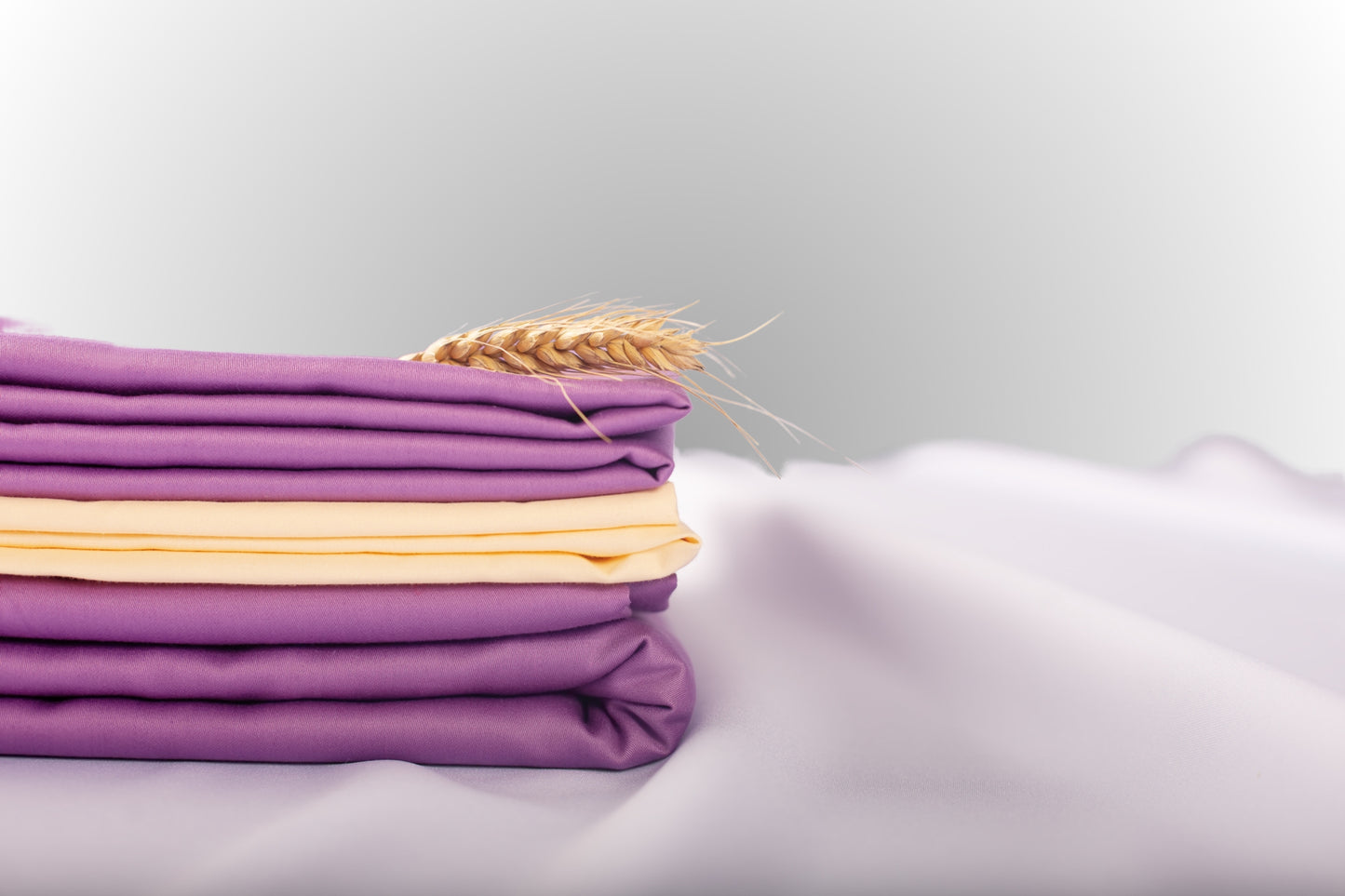 Texture detail of cream and purple sateen bed linen by Once@Home with subtle sheen and soft touch