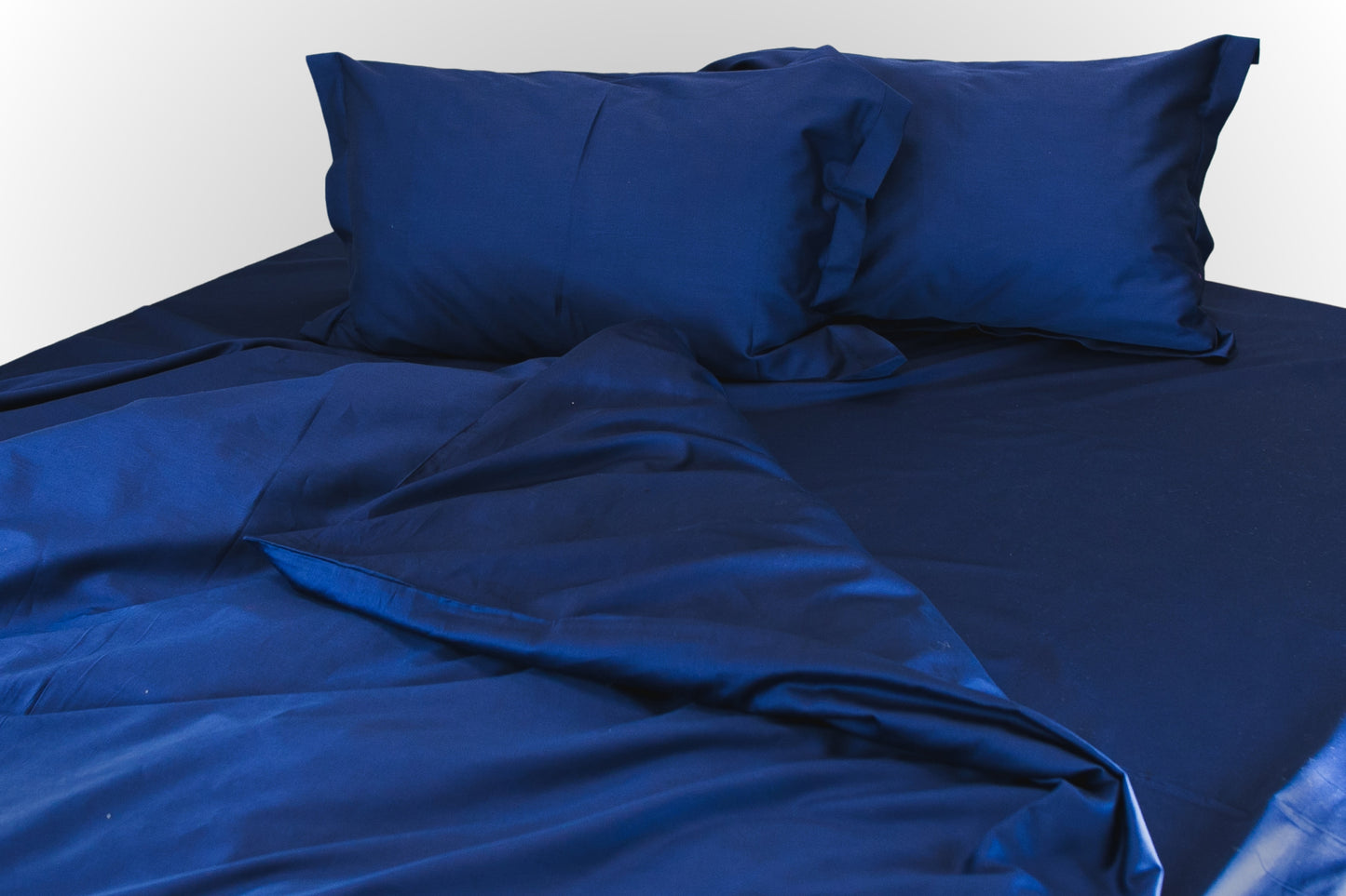 Styled dark blue sateen bed linen by Once@Home in a calm, refined setting