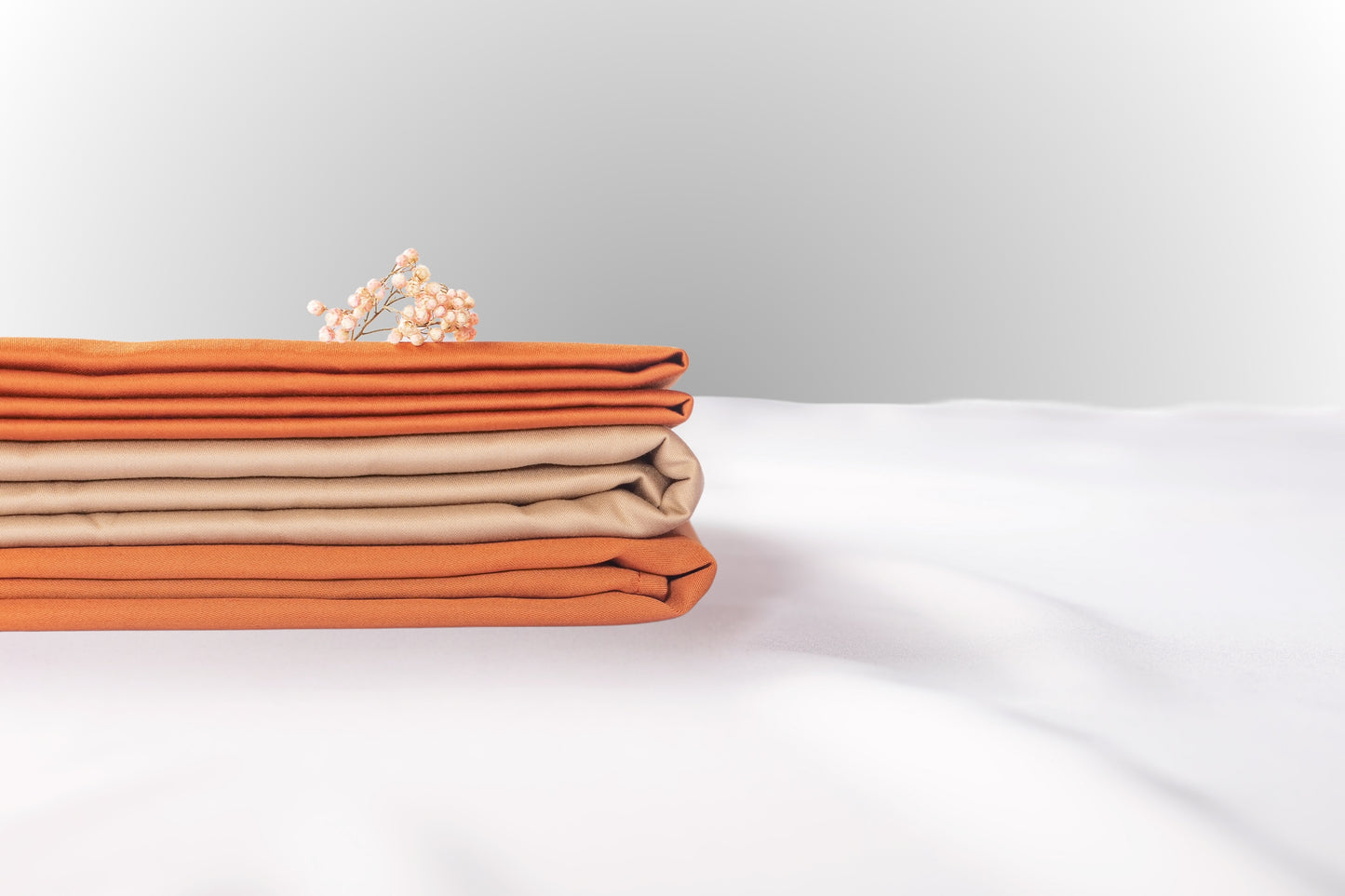 Texture detail of terracotta and beige sateen bed linen by Once@Home with subtle sheen and soft touch