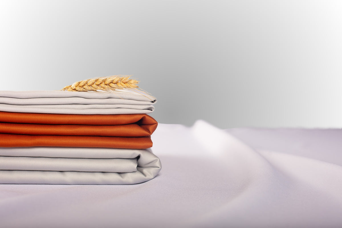 Texture detail of silver and terracotta sateen bed linen by Once@Home with subtle sheen and soft touch