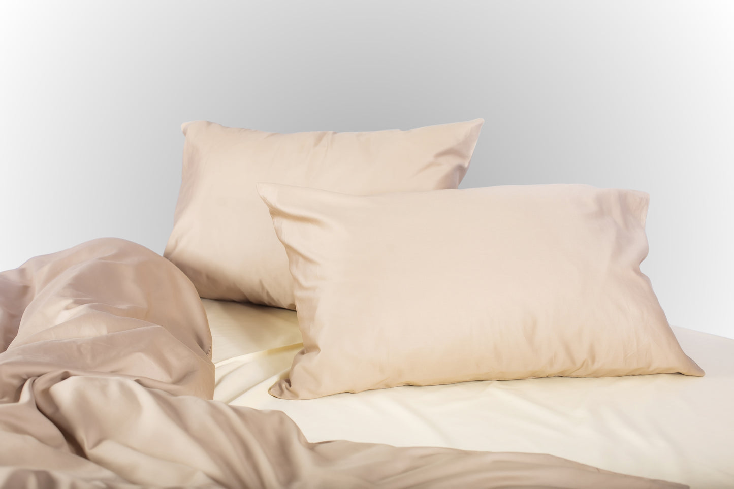 Beige-cream sateen bed linen by Once@Home with soft pillows and a smooth, elegant drape
