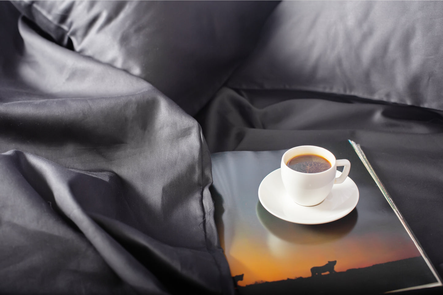 Close-up of black sateen bed linen by Once@Home showing gentle folds and refined finish