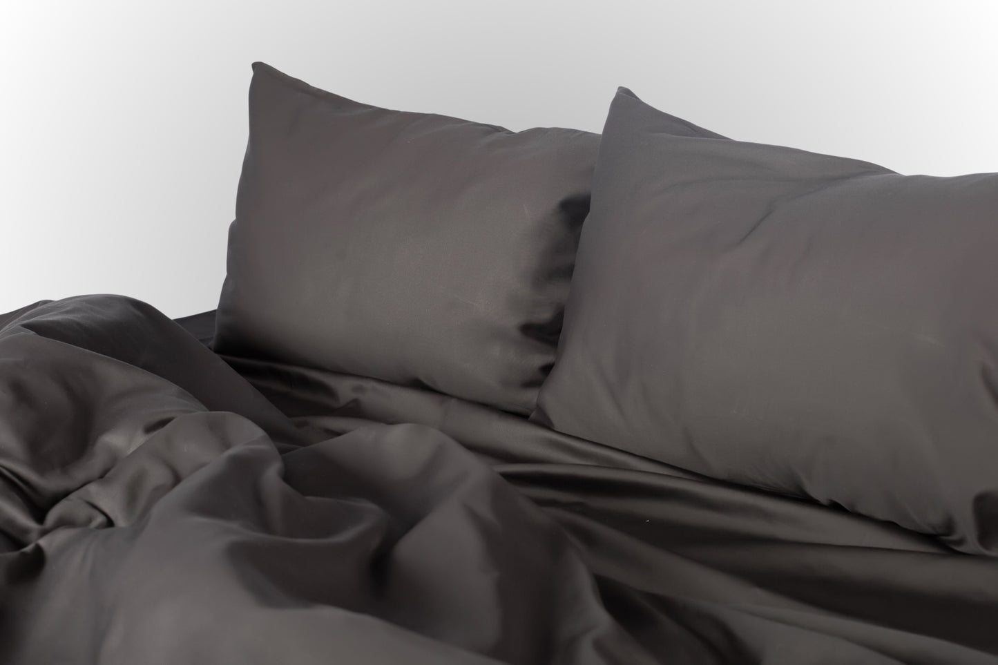 Black sateen bed linen by Once@Home with soft pillows and a smooth, elegant drape