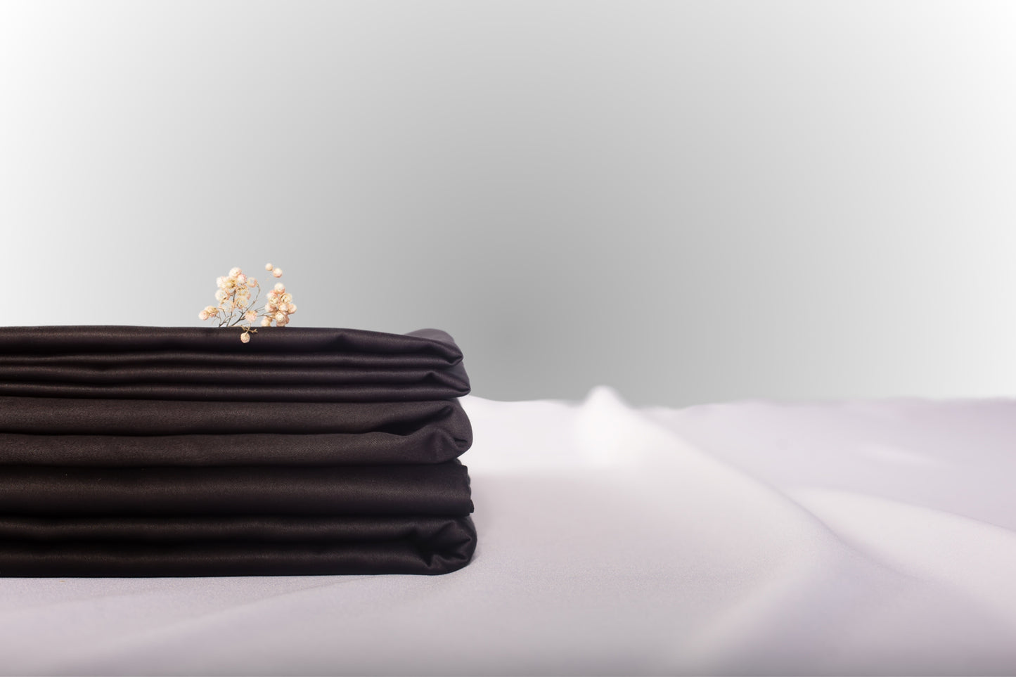 Texture detail of black sateen bed linen by Once@Home with subtle sheen and soft touch