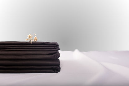 Texture detail of black sateen bed linen by Once@Home with subtle sheen and soft touch