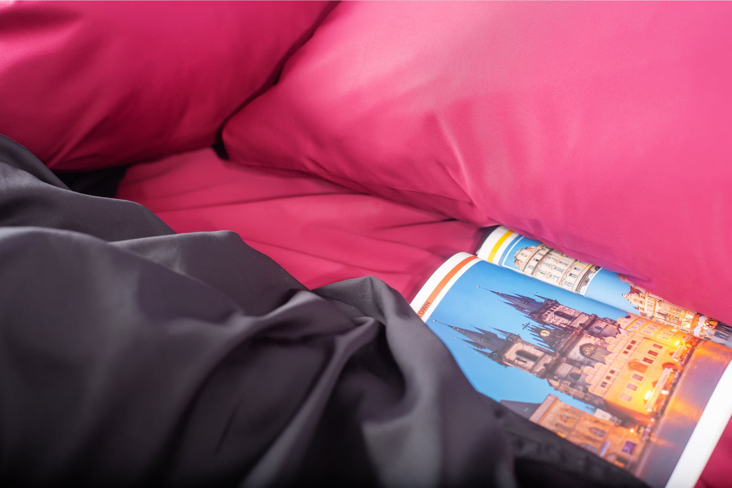 Close-up of burgundy and black sateen bed linen by Once@Home showing gentle folds and refined finish