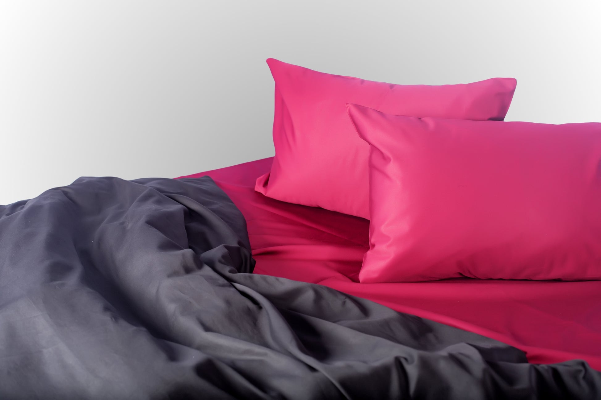 Styled burgundy and black sateen bed linen by Once@Home creating a deep and sophisticated bedroom atmosphere