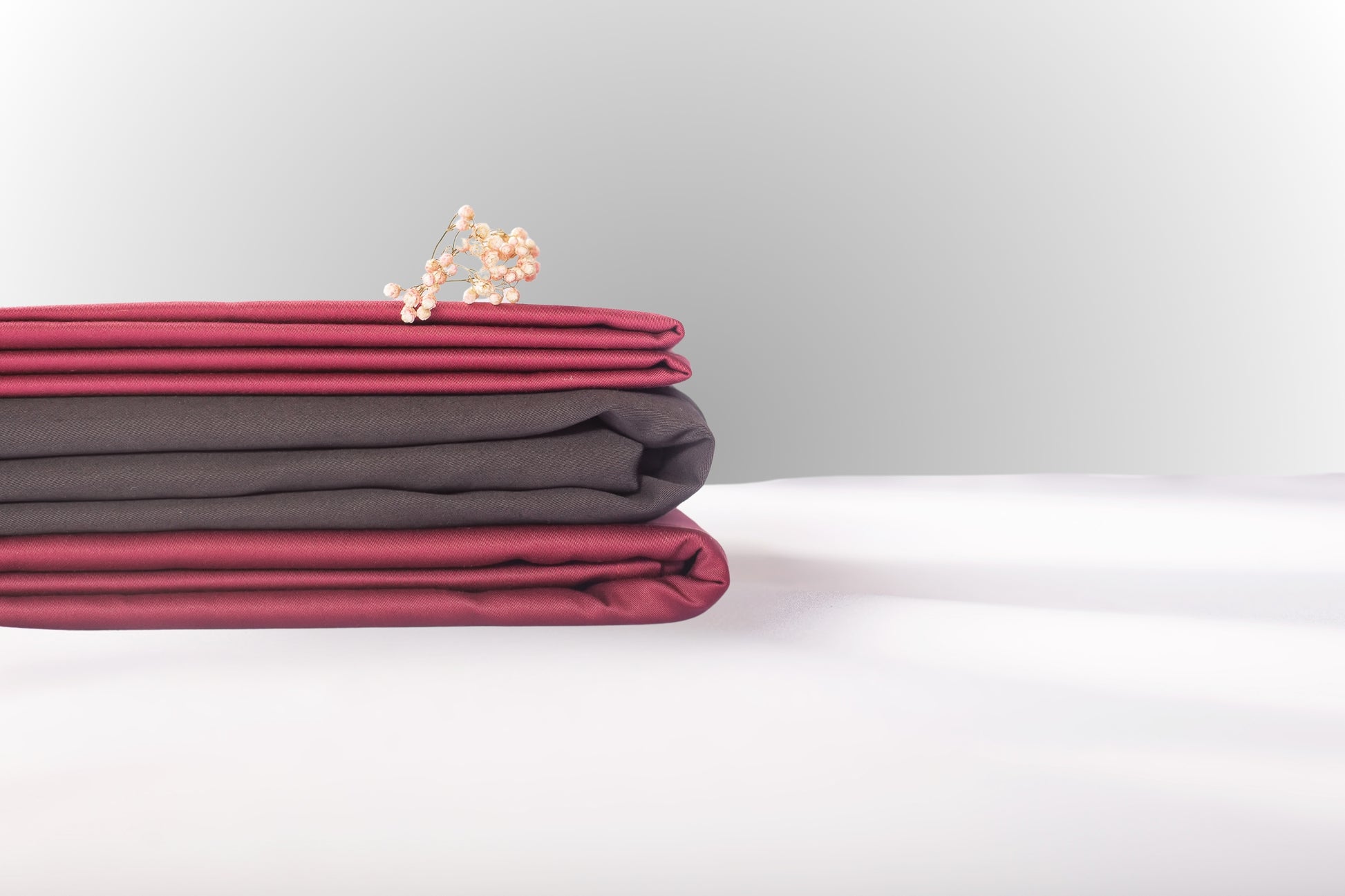 Texture detail of burgundy and black sateen bed linen by Once@Home with subtle sheen and soft touch
