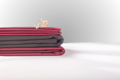 Texture detail of burgundy and black sateen bed linen by Once@Home with subtle sheen and soft touch