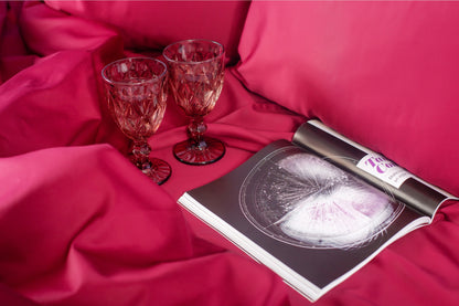 Close-up of burgundy sateen bed linen by Once@Home showing gentle folds and refined finish