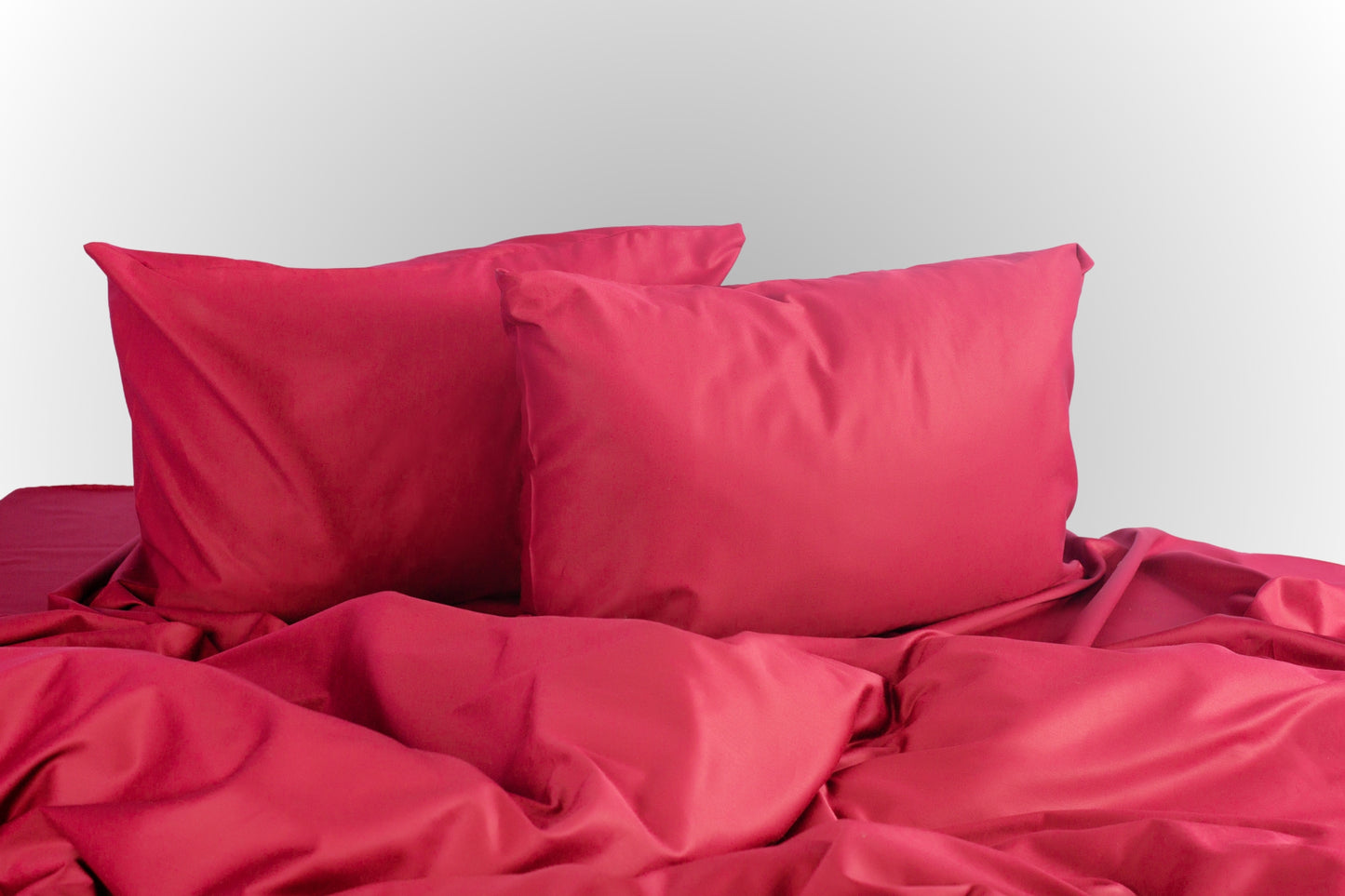 Burgundy sateen bed linen by Once@Home with soft pillows and a smooth, elegant drape