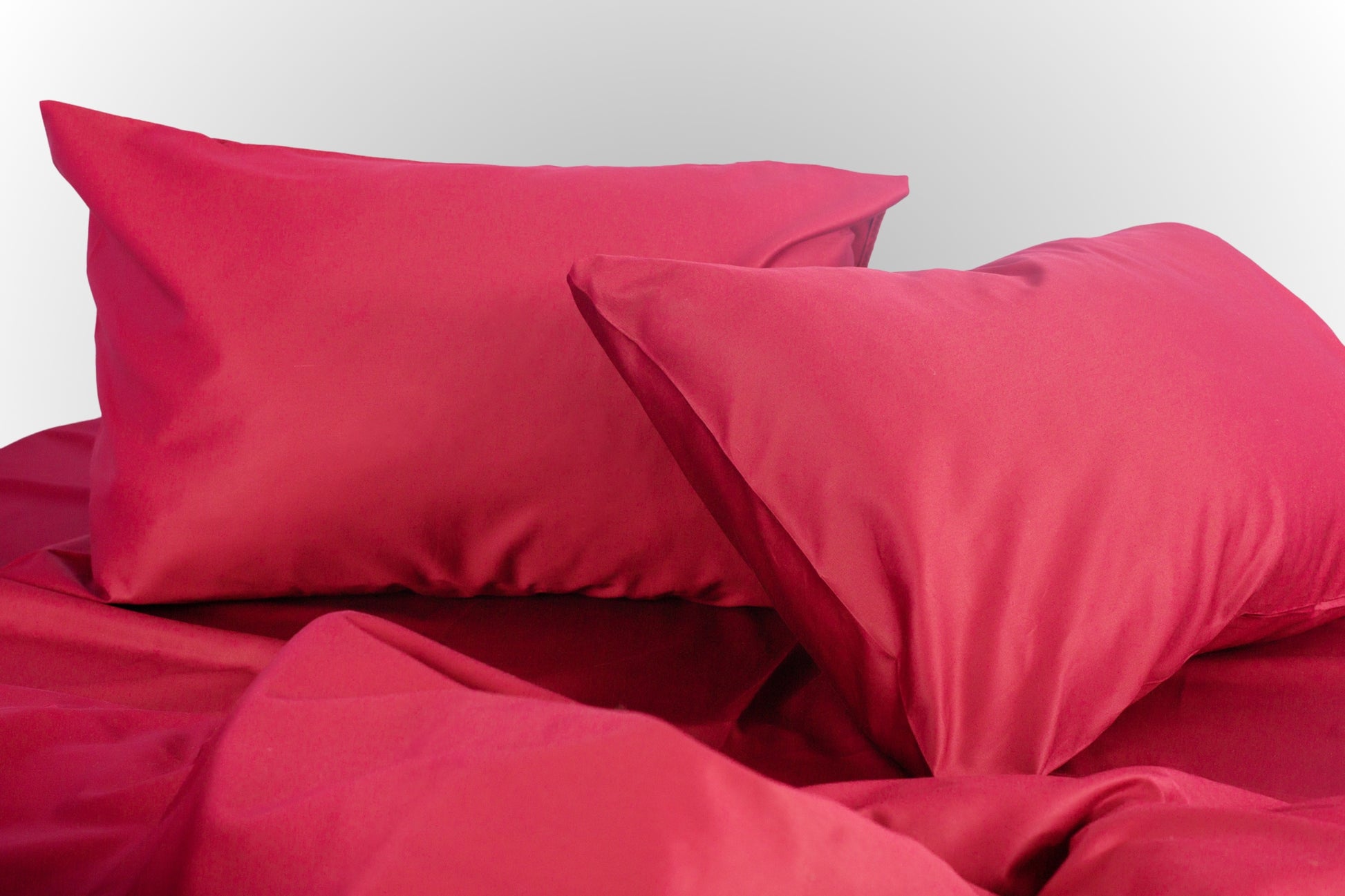 Styled burgundy sateen bed linen by Once@Home creating a warm and refined bedroom atmosphere