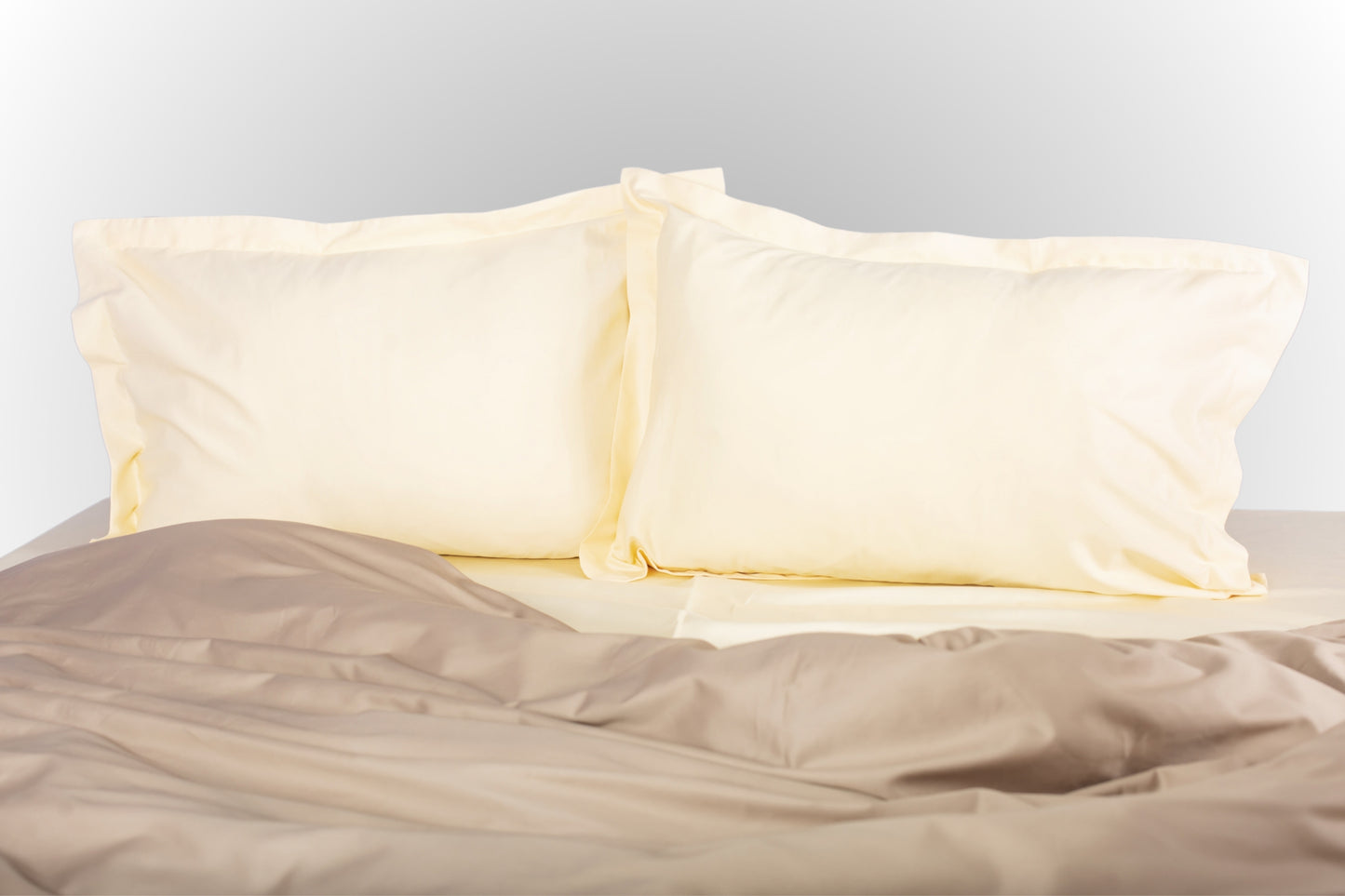 Cream-beige sateen bed linen by Once@Home with soft pillows and a smooth, elegant drape