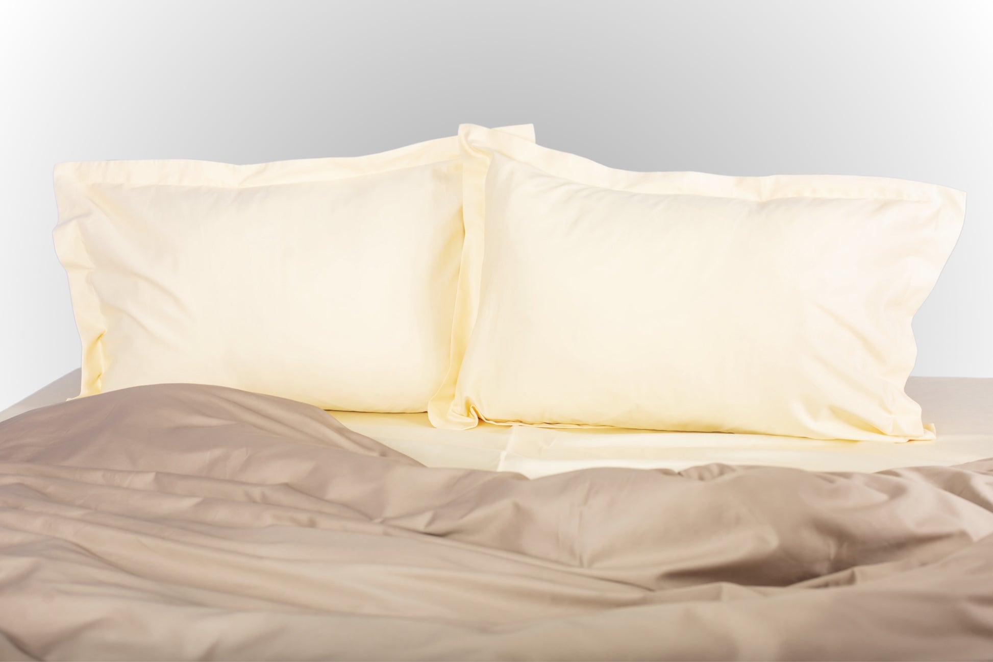 Cream-beige sateen bed linen by Once@Home with soft pillows and a smooth, elegant drape
