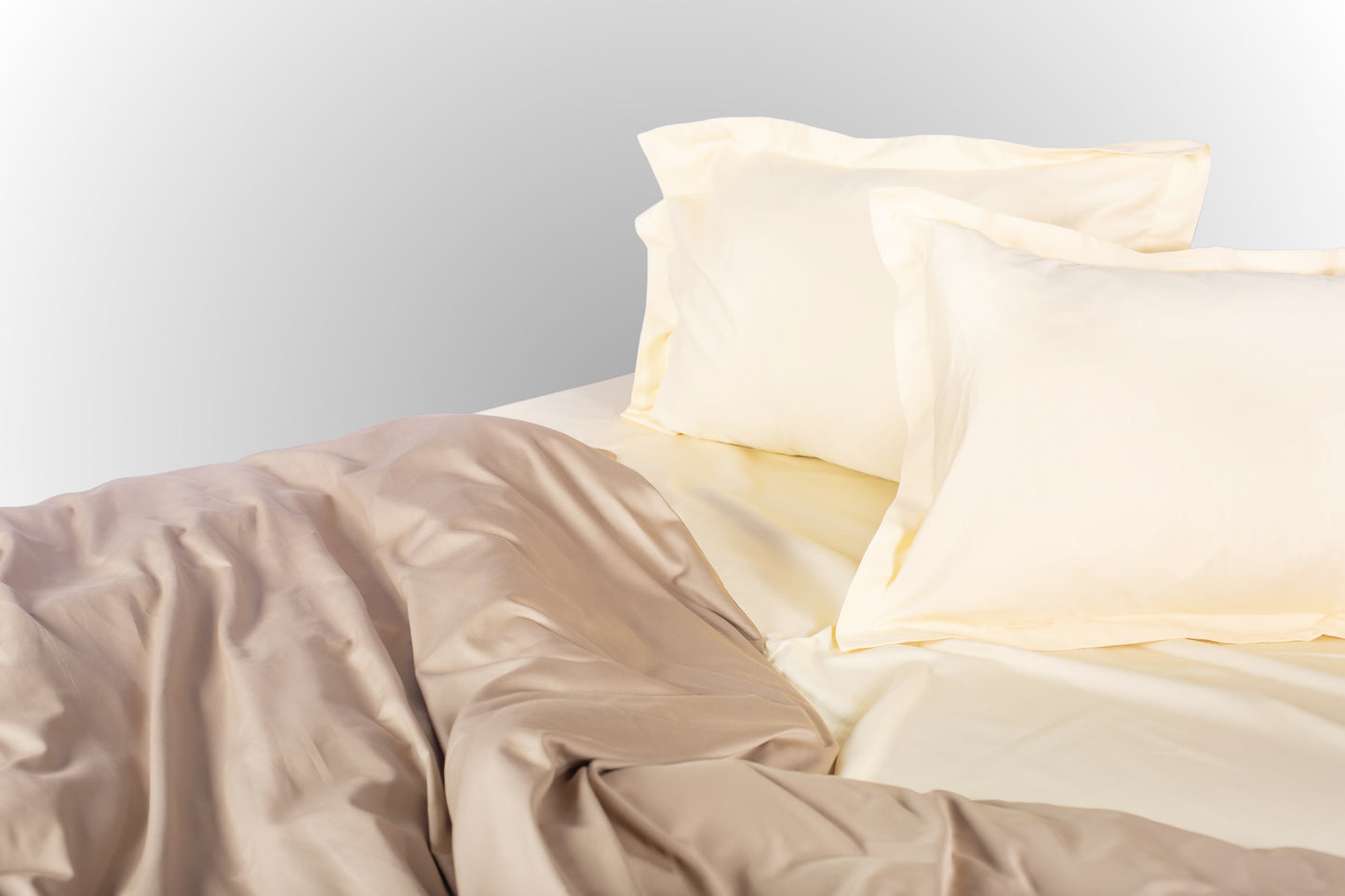 Cream-beige sateen bed linen by Once@Home with soft pillows and a smooth, elegant drape