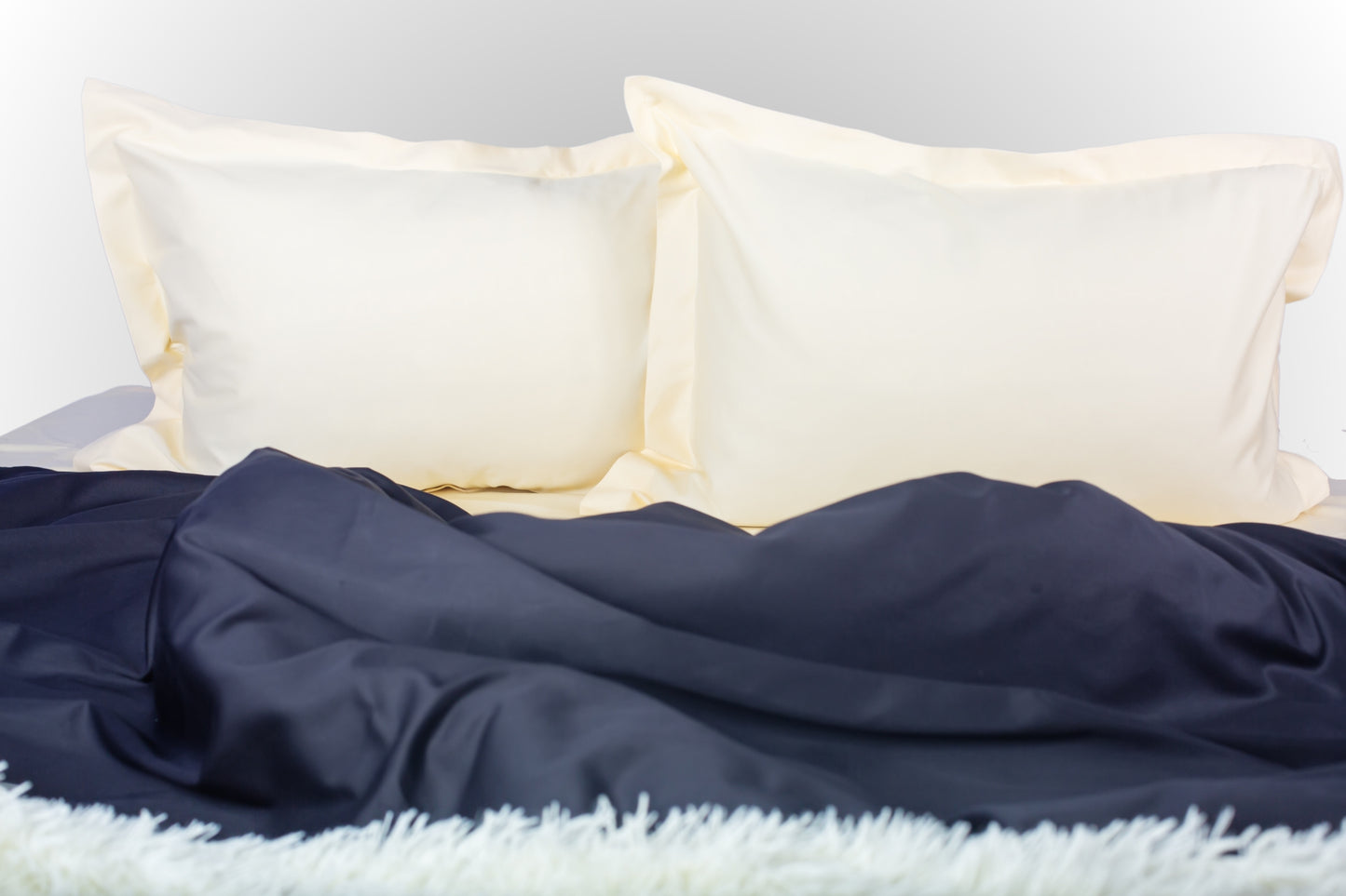 Cream and black sateen bed linen by Once@Home with soft pillows and a smooth, elegant drape