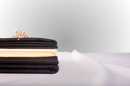 Texture detail of cream and black sateen bed linen by Once@Home with subtle sheen and soft touch