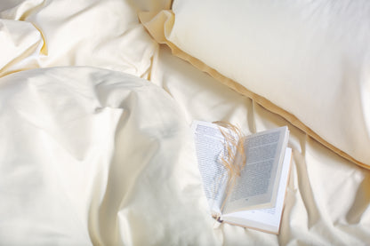 Close-up of cream sateen bed linen by Once@Home showing gentle folds and refined finish