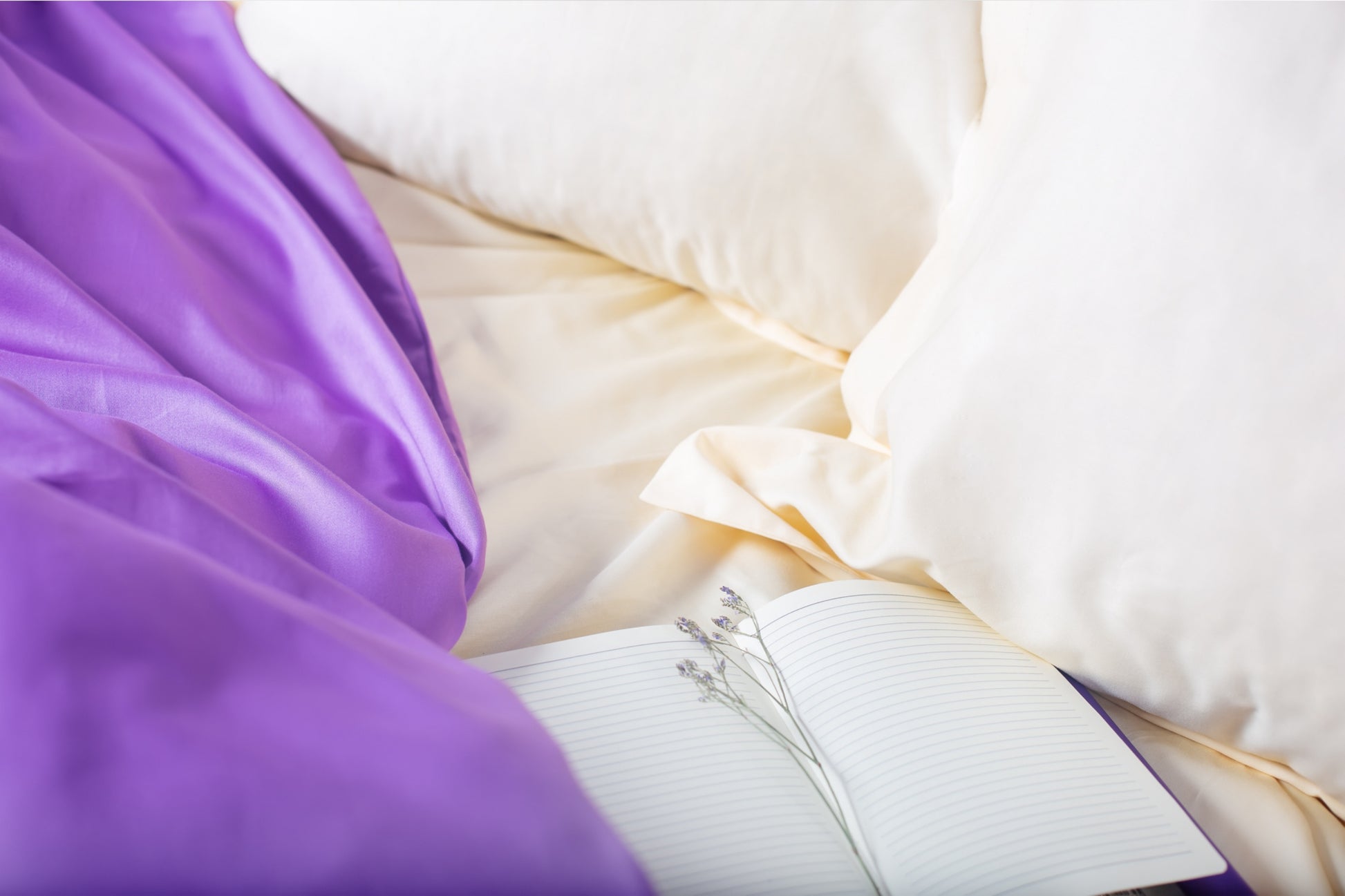 Close-up of cream and purple sateen bed linen by Once@Home showing gentle folds and refined finish