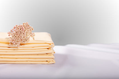 Texture detail of cream sateen bed linen by Once@Home with subtle sheen and soft touch