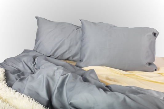 Grey and cream sateen bed linen by Once@Home with soft pillows and a smooth, elegant drape