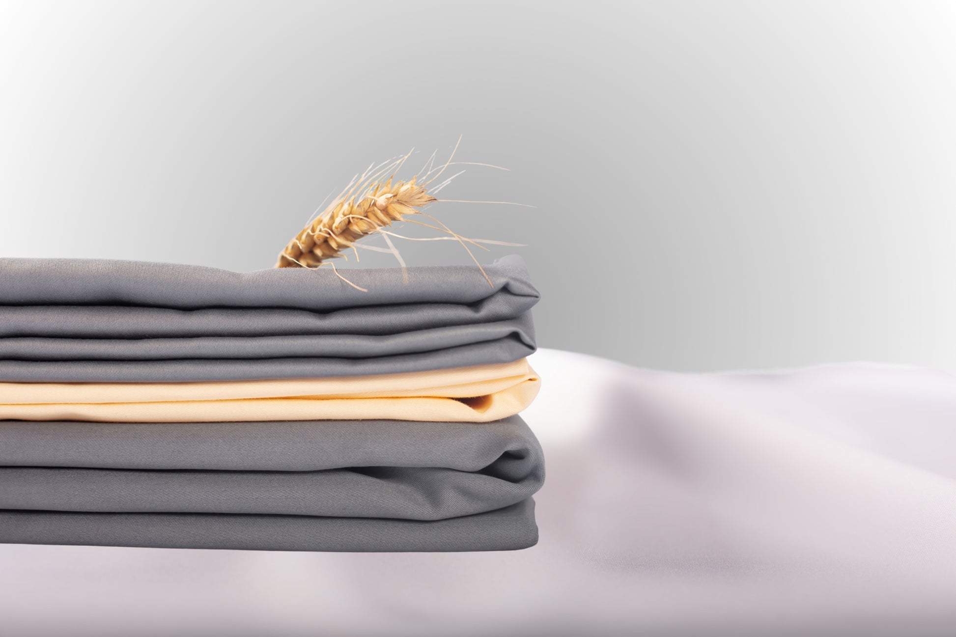 Texture detail of grey and cream sateen bed linen by Once@Home with subtle sheen and soft touch