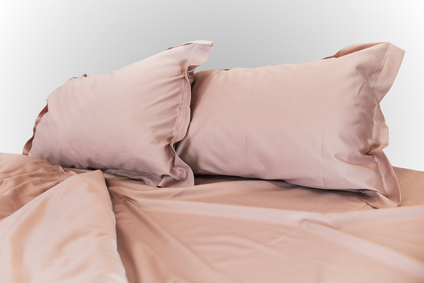 Close-up of pale pink sateen bed linen by Once@Home highlighting smooth weave and gentle sheen