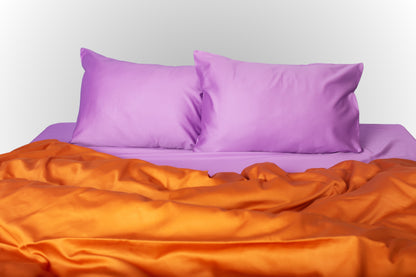Styled purple and terracotta sateen bed linen by Once@Home creating a warm and expressive bedroom mood