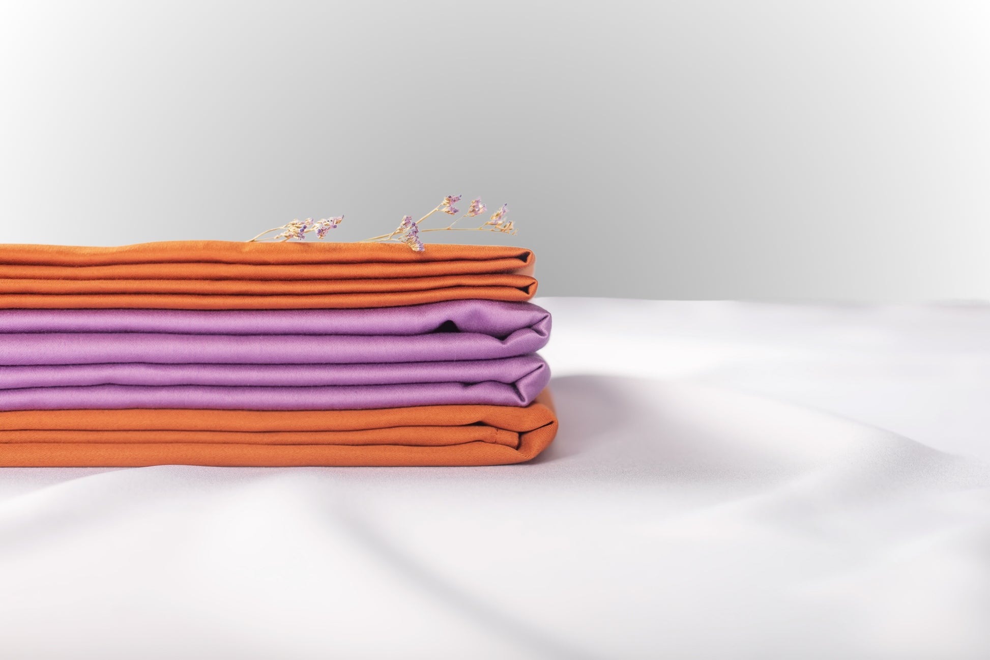 Texture detail of purple and terracotta sateen bed linen by Once@Home with subtle sheen and soft touch