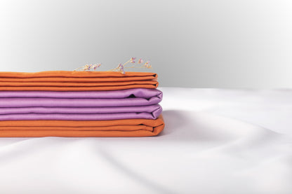 Texture detail of purple and terracotta sateen bed linen by Once@Home with subtle sheen and soft touch