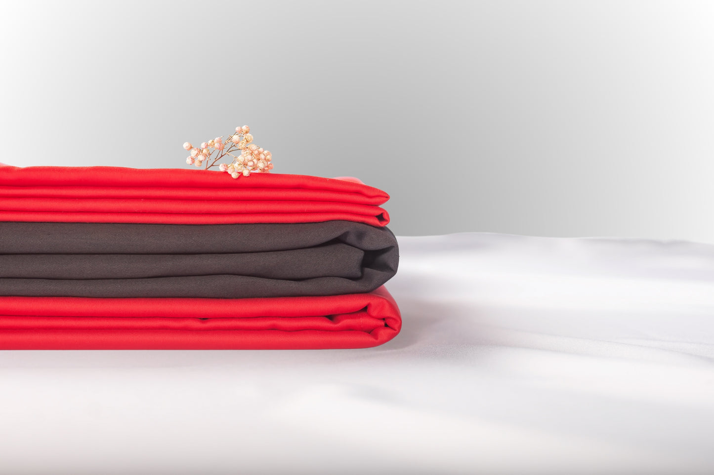 Texture detail of red and black sateen bed linen by Once@Home with subtle sheen and soft touch