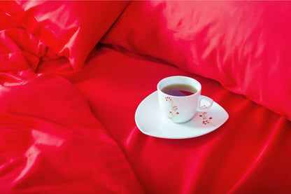 Close-up of red sateen bed linen by Once@Home showing gentle folds and refined finish