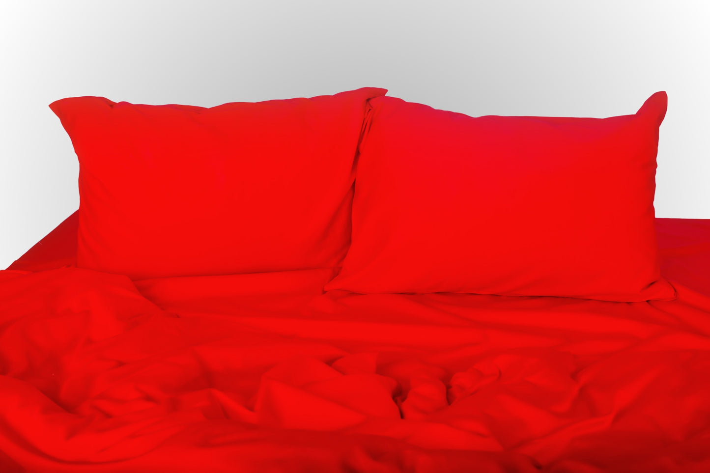 Red sateen bed linen by Once@Home with soft pillows and a smooth, elegant drape