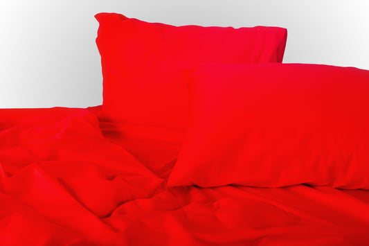 Styled red sateen bed linen by Once@Home creating a warm and expressive bedroom atmosphere