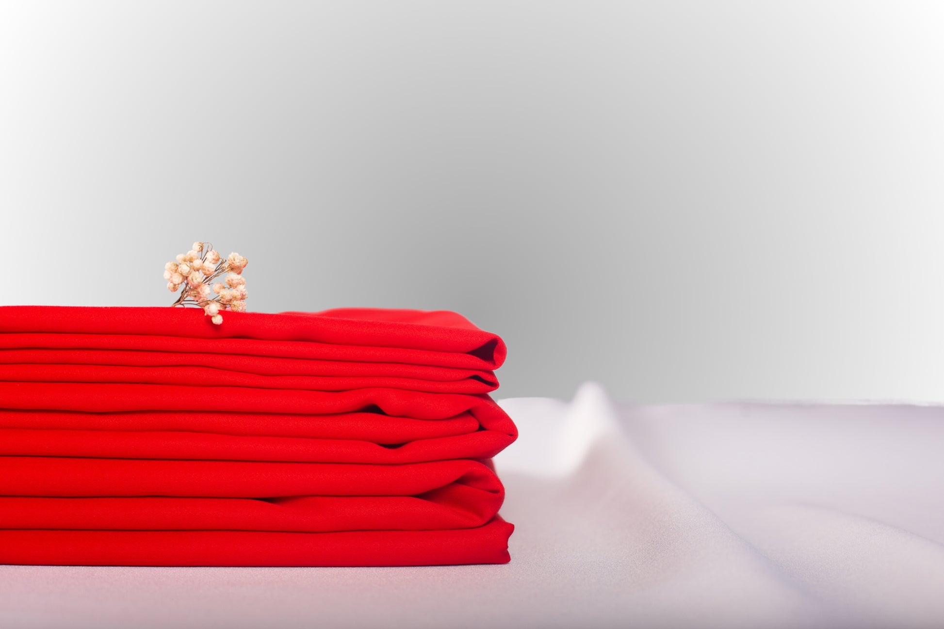 Texture detail of red sateen bed linen by Once@Home with subtle sheen and soft touch