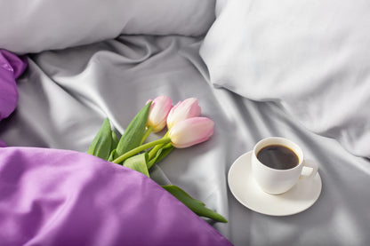 Close-up of silver and purple sateen bed linen by Once@Home showing gentle folds and refined finish