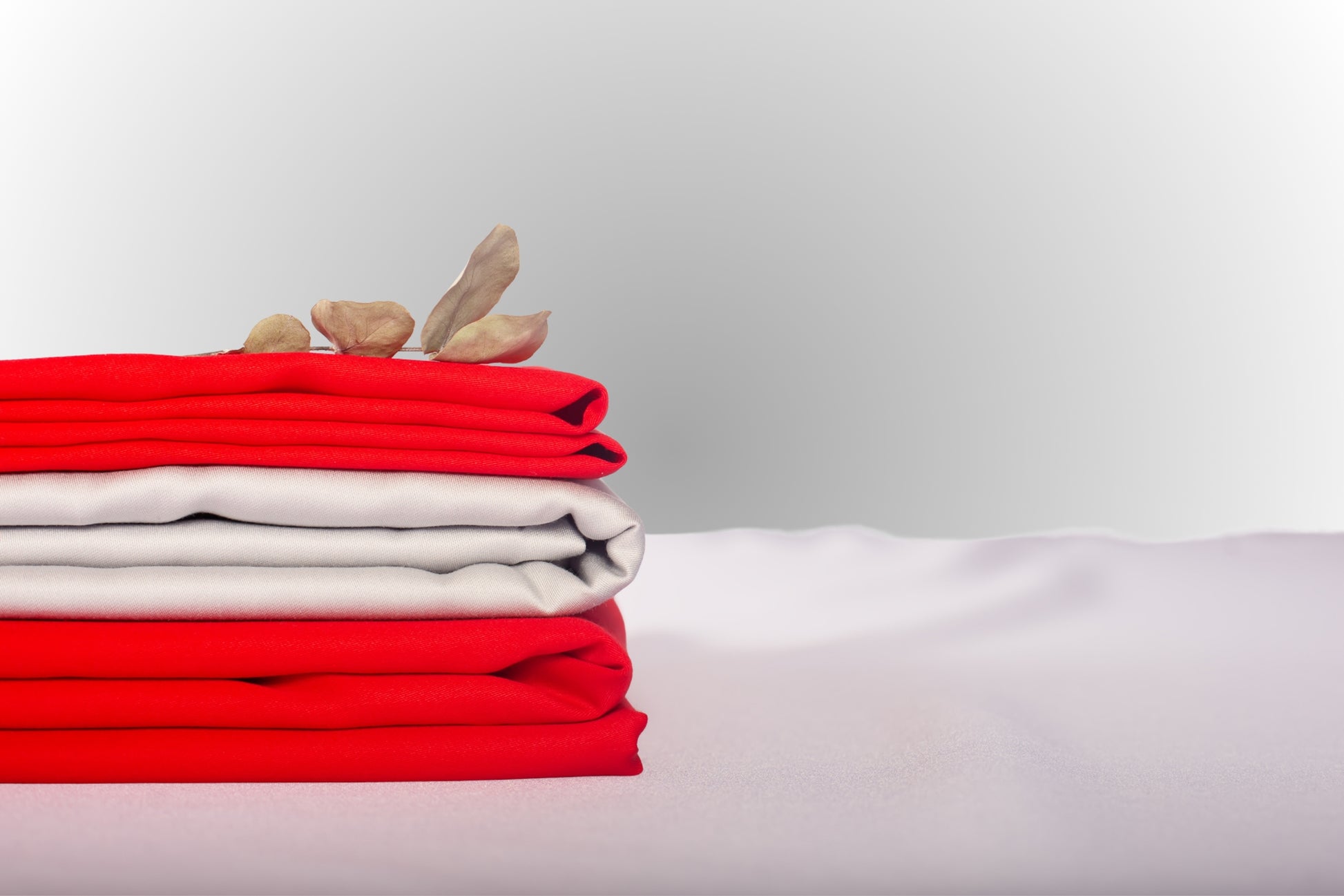 Texture detail of silver and red sateen bed linen by Once@Home with subtle sheen and soft touch