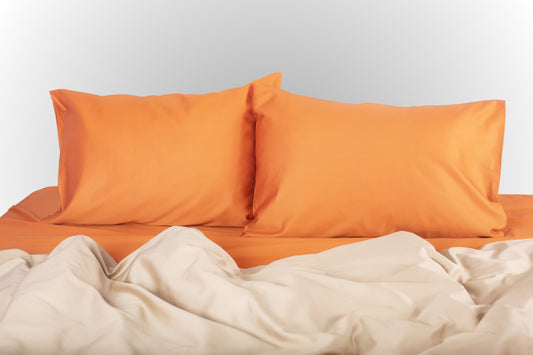 Terracotta-beige sateen bed linen by Once@Home with soft pillows and an elegant, smooth drape