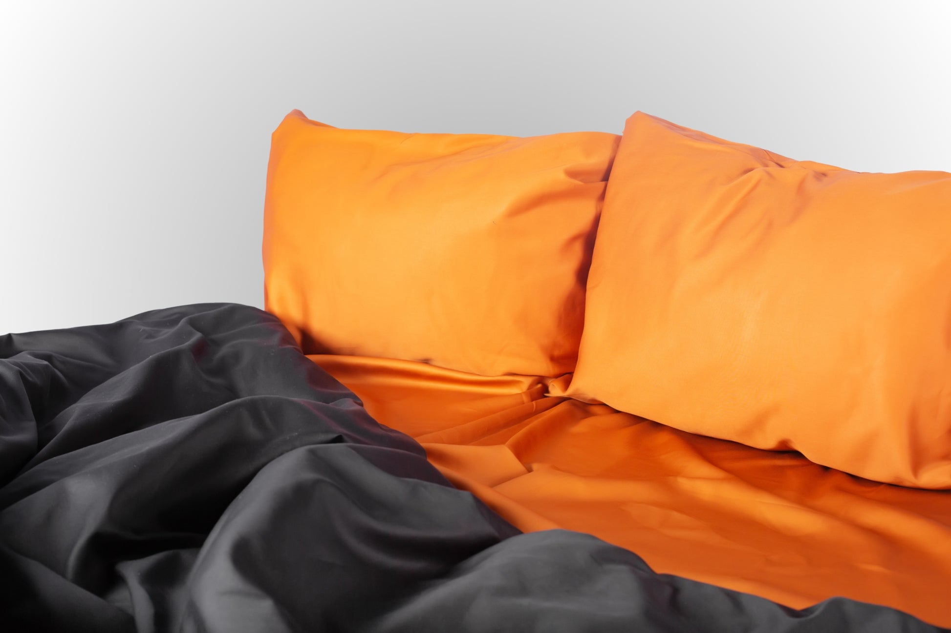 Styled terracotta and black sateen bed linen by Once@Home creating a warm and sophisticated bedroom atmosphere