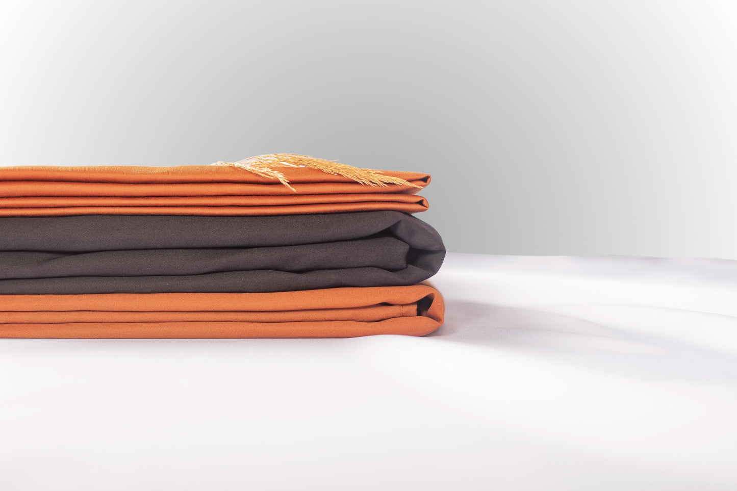 Texture detail of terracotta and black sateen bed linen by Once@Home with subtle sheen and soft touch