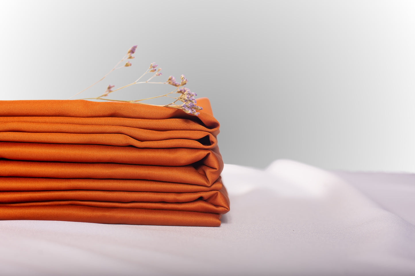 Texture detail of terracotta sateen bed linen by Once@Home with subtle sheen and soft touch