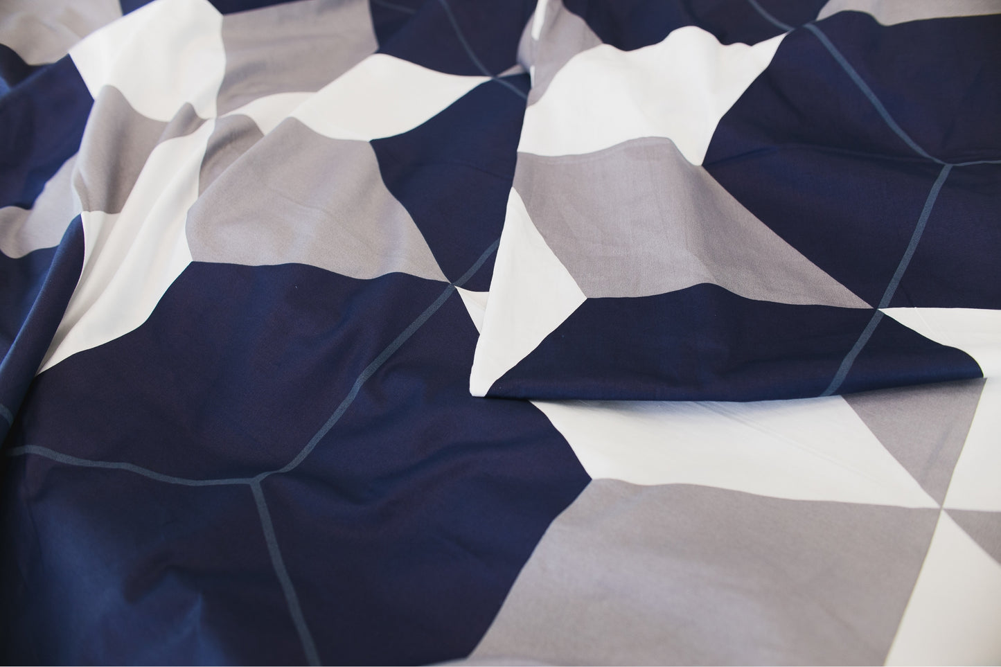 Close-up of sateen bed linen by Once@Home highlighting geometric design and silky texture