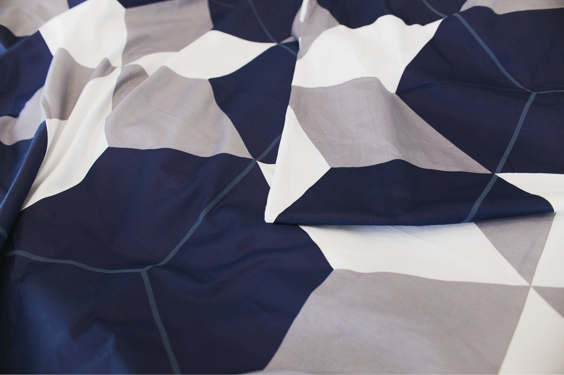 Close-up of sateen bed linen by Once@Home highlighting geometric design and silky texture