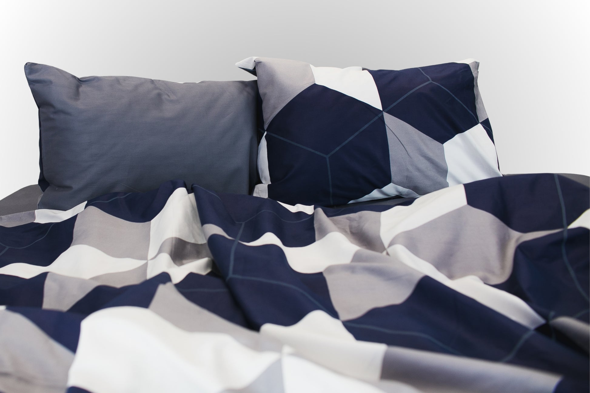 Styled geometric sateen bed linen by Once@Home arranged in a calm, modern interior